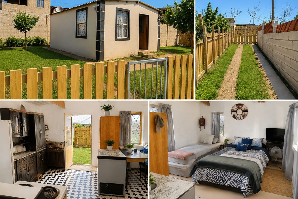 Open-plan studio unit featuring a kitchenette with built-in cabinetry, checkerboard flooring, and exposed roof beams, set within a fenced garden property.