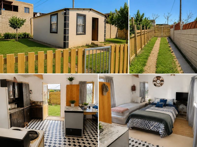 Open-plan studio unit featuring a kitchenette with built-in cabinetry, checkerboard flooring, and exposed roof beams, set within a fenced garden property.