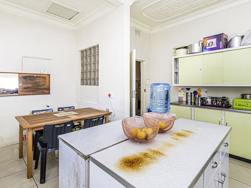 A dated kitchen featuring built-in cabinetry, a central island, and tiled flooring, offering significant potential for modernization and renovation.