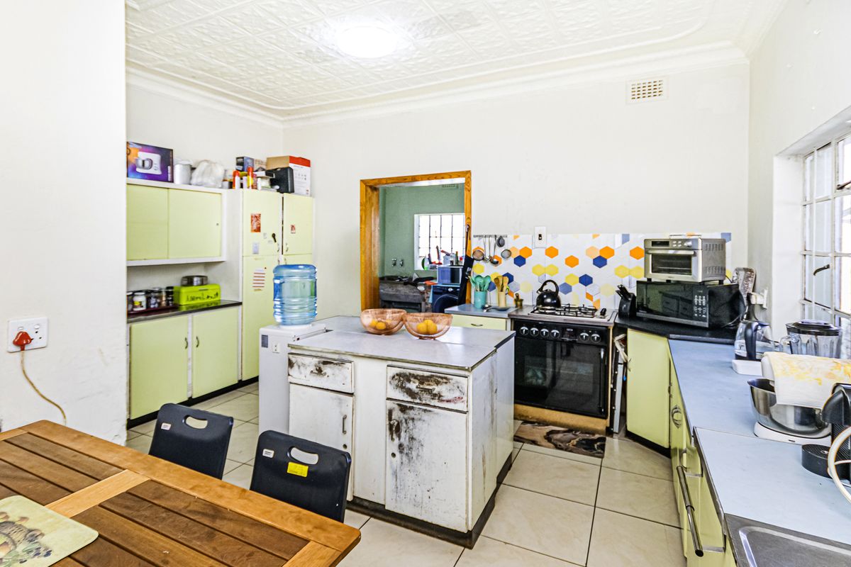 A functional kitchen featuring built-in cabinetry, a gas stove, and tiled flooring, with potential for cosmetic updates to modernize the space.