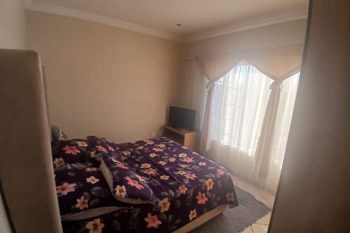 A bedroom featuring tiled flooring, recessed downlighting, and coved cornicing, providing a functional space with natural light from the window.