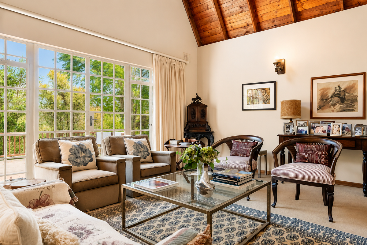 A bright and spacious living room featuring a high vaulted timber ceiling, large windows providing natural light, and neutral carpeted flooring.