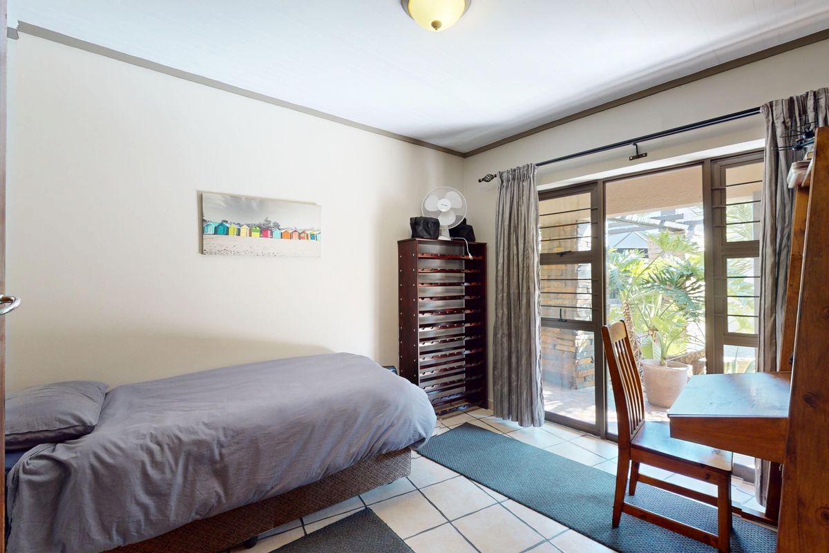 A bedroom featuring tiled flooring and a sliding glass door providing direct access to an outdoor patio area.