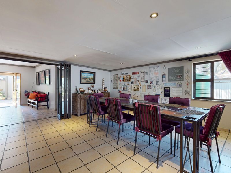 Spacious dining room featuring tiled flooring, recessed lighting, and bi-fold doors providing seamless access to the adjacent outdoor area.