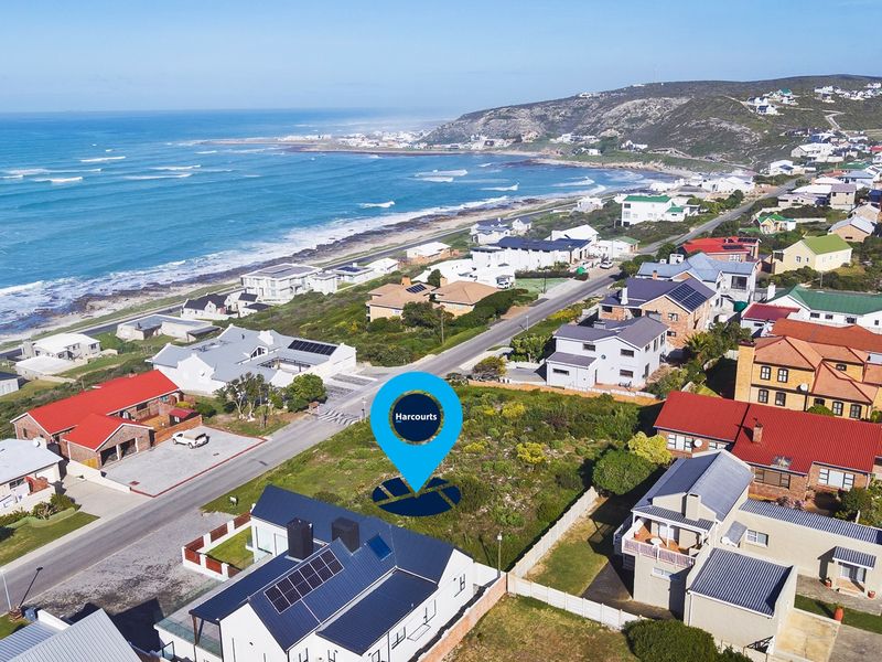 Aerial view of a vacant residential plot situated in a coastal neighborhood, offering proximity to the ocean and established residential infrastructure.