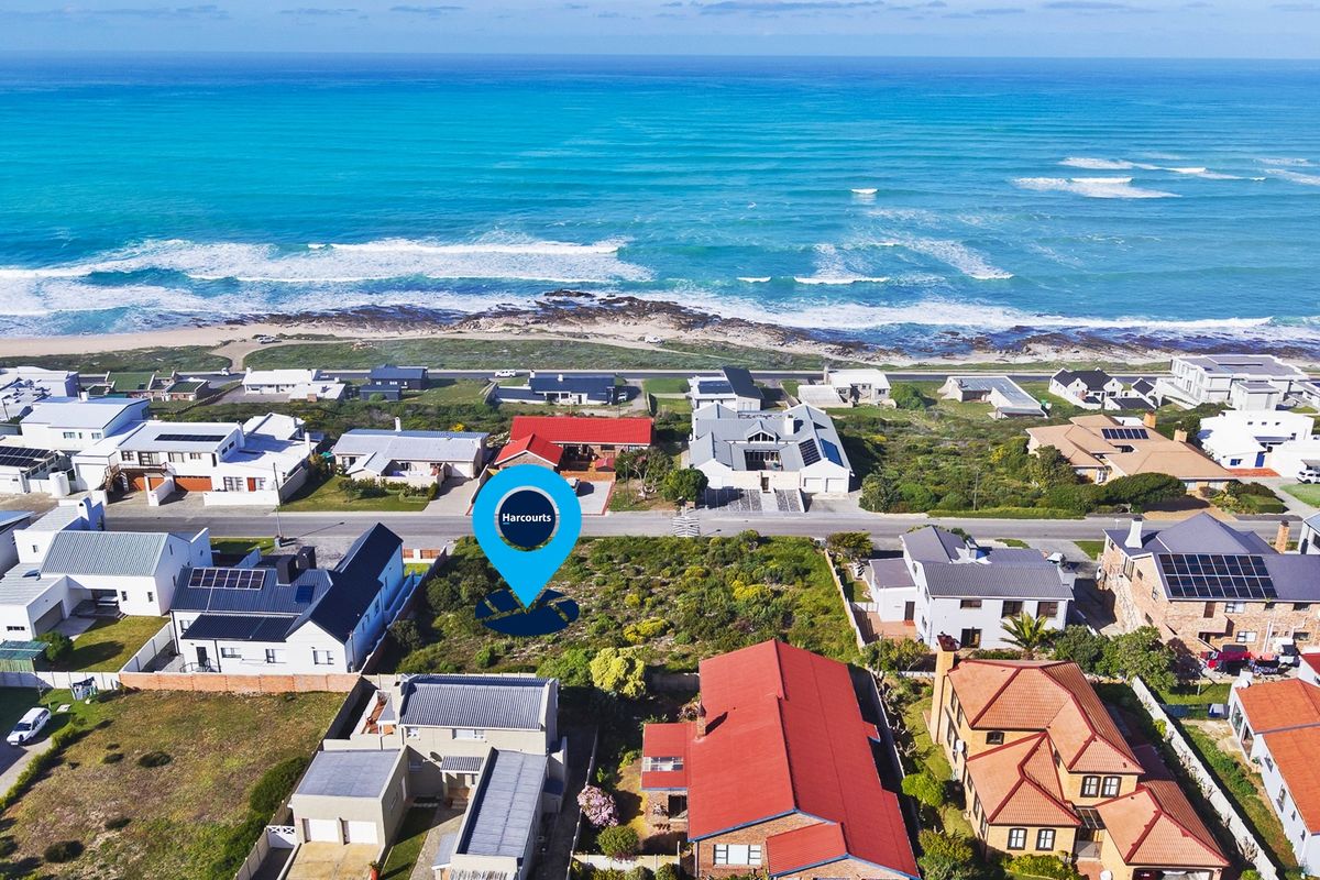 Aerial view of a vacant residential plot situated in a prime coastal location with direct proximity to the ocean.