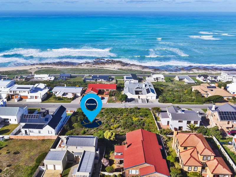 Aerial view of a vacant residential plot situated in a prime coastal location with direct proximity to the ocean.