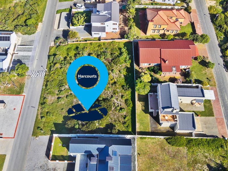 An aerial view of a vacant residential plot situated within an established neighborhood, showing surrounding properties and access roads.