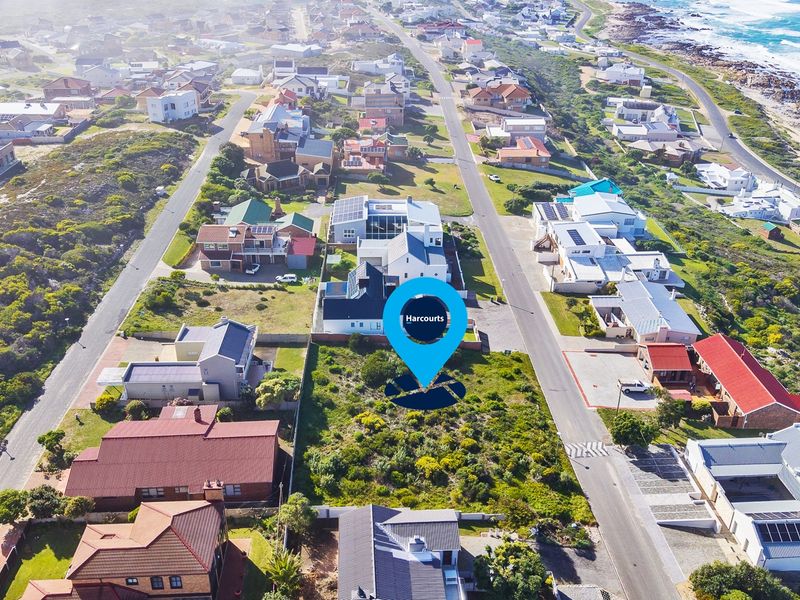 Aerial view of a vacant residential plot situated in a developed coastal neighborhood, offering proximity to the ocean and local infrastructure.
