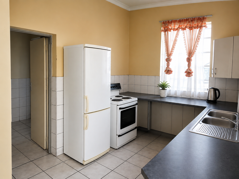 A functional kitchen featuring tiled flooring, a tiled backsplash, built-in cabinetry, and a stainless steel double sink.