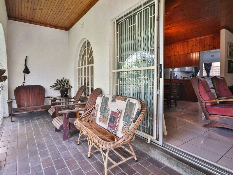 A covered patio featuring tiled flooring and a timber ceiling, providing seamless access to the interior living space through a sliding glass door.
