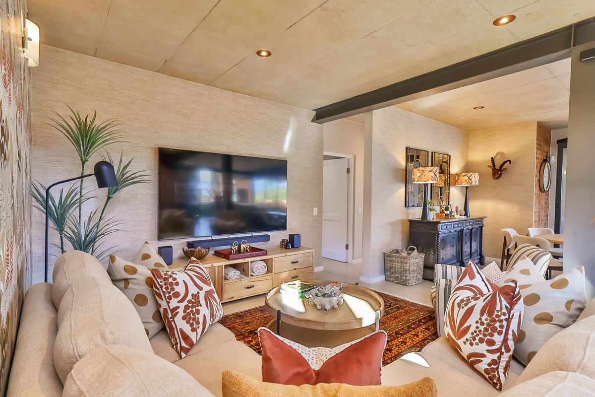 A well-appointed living room featuring a textured wall finish, exposed steel beam, and recessed lighting, creating a warm and inviting atmosphere.