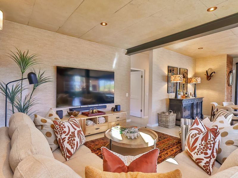 A well-appointed living room featuring a textured wall finish, exposed steel beam, and recessed lighting, creating a warm and inviting atmosphere.