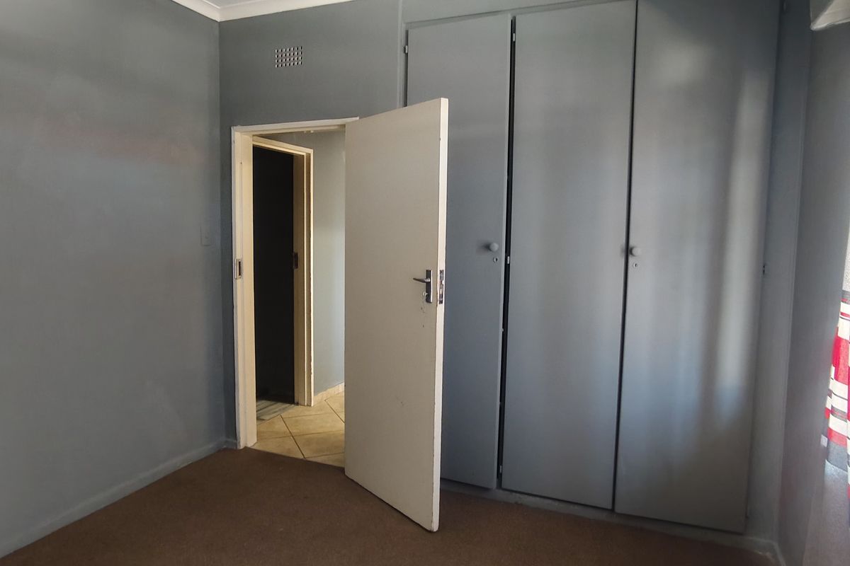 A vacant bedroom featuring built-in cupboards and neutral wall finishes, offering a blank canvas for potential interior updates.