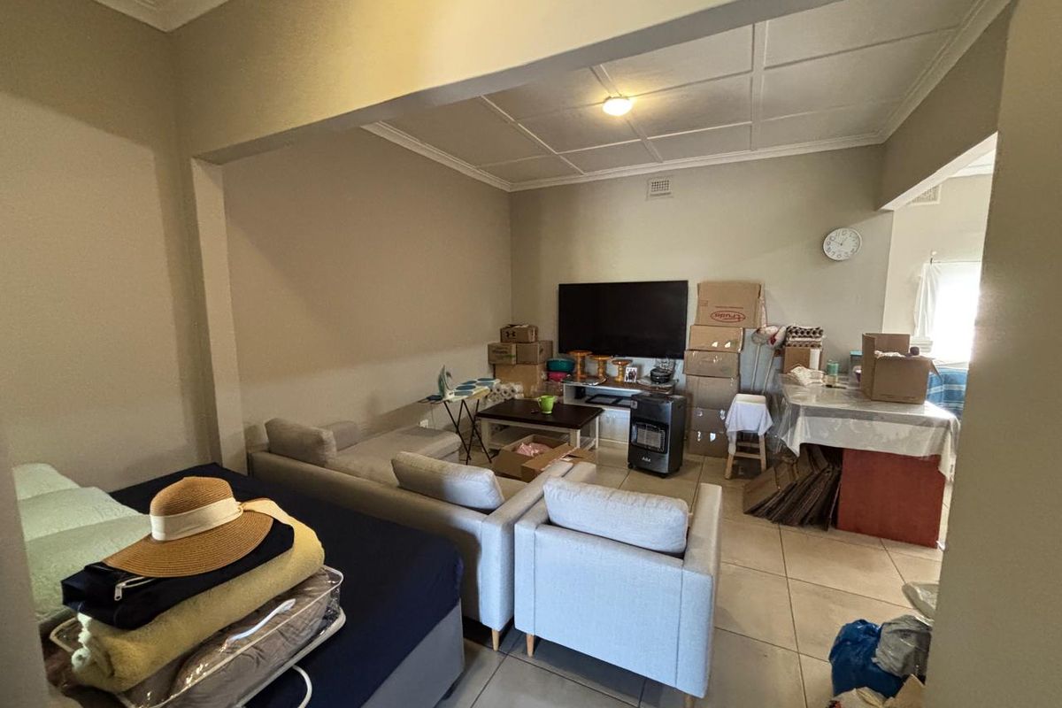 A living room area featuring tiled flooring and a tiled ceiling, offering a functional space for relaxation and daily living.