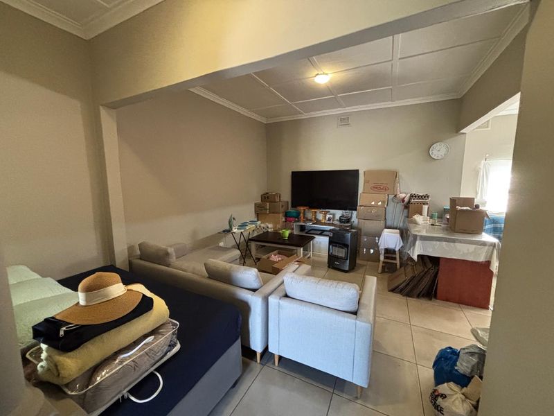 A living room area featuring tiled flooring and a tiled ceiling, offering a functional space for relaxation and daily living.