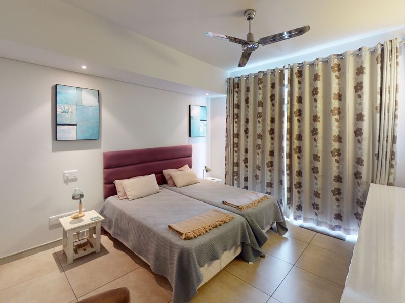A well-maintained bedroom featuring tiled flooring, a ceiling fan, recessed lighting, and built-in wardrobe storage.