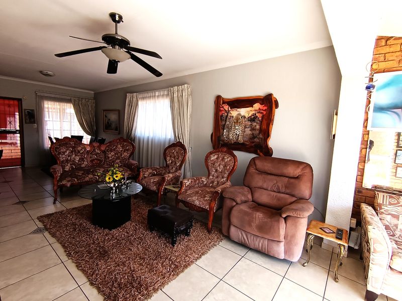 A spacious living room featuring tiled flooring and a ceiling fan, providing a comfortable and functional area for relaxation.
