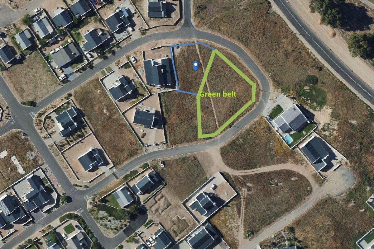 Aerial view of a vacant residential plot situated adjacent to a designated green belt area in a developed neighborhood.