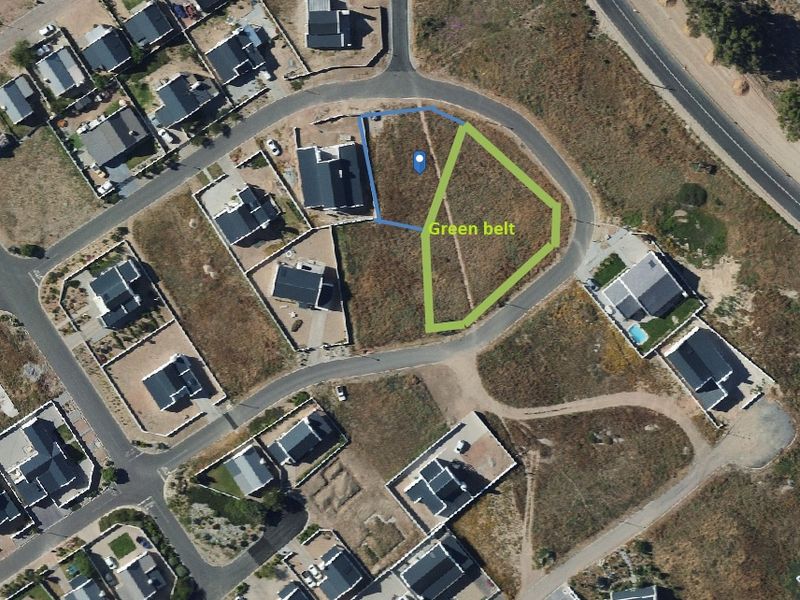 Aerial view of a vacant residential plot situated adjacent to a designated green belt area in a developed neighborhood.