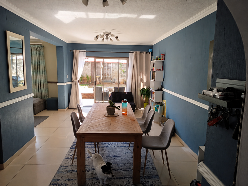 Dining area featuring tiled floors, crown molding, and sliding glass doors providing access to the rear patio area.