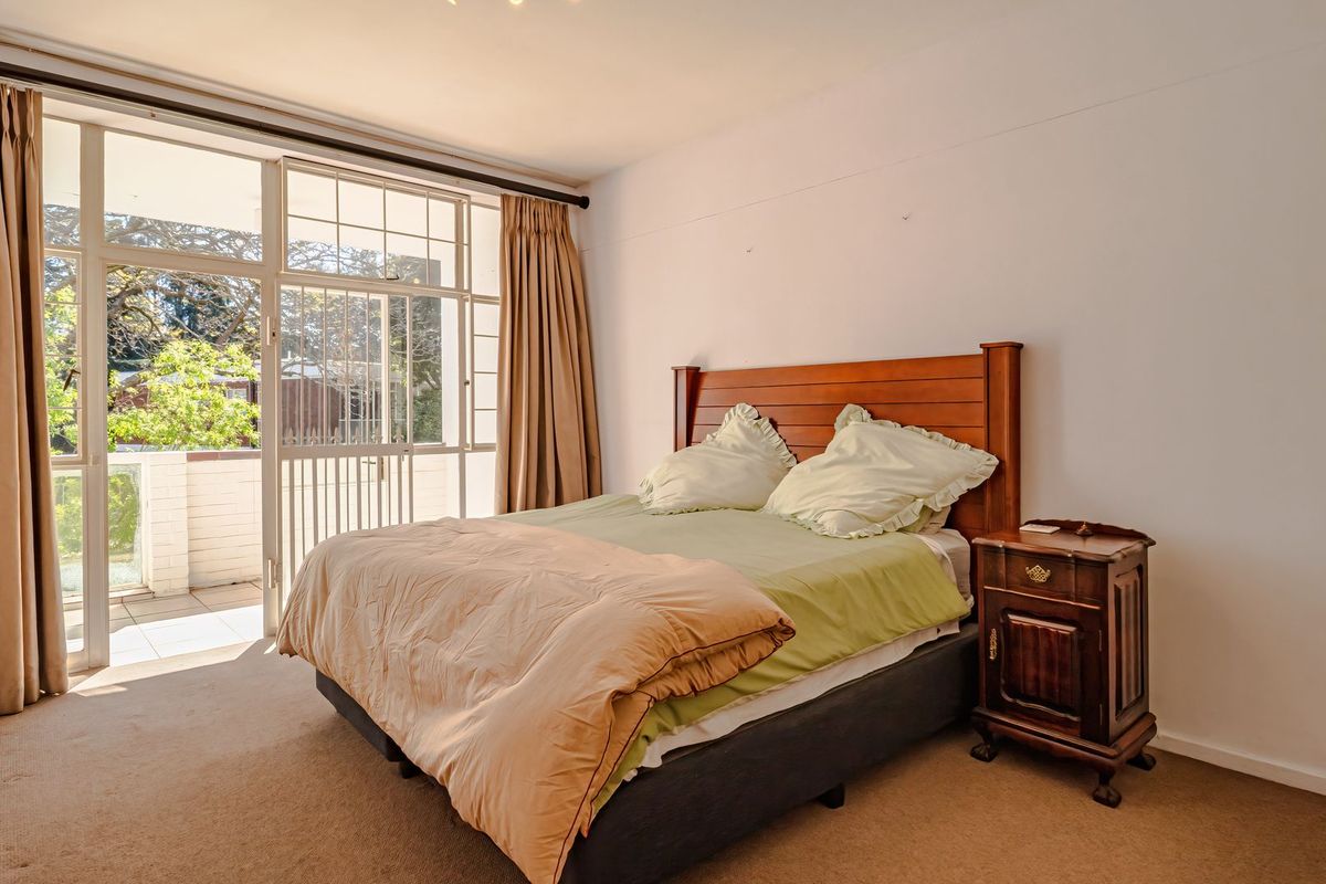 Spacious bedroom featuring neutral carpeting and a large sliding glass door providing access to a private balcony.