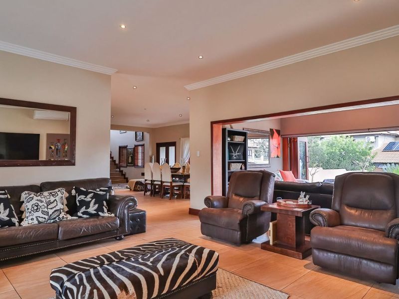 Spacious open-plan living area featuring tiled floors, recessed lighting, and large sliding doors that provide seamless access to the outdoor patio space.