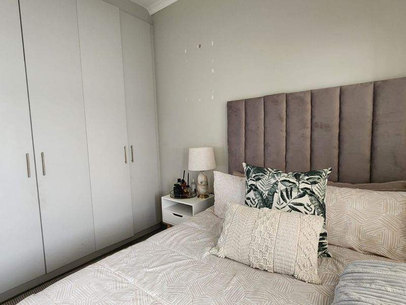 A bedroom featuring floor-to-ceiling built-in cupboards and neutral wall finishes.