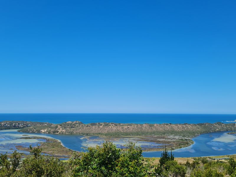A scenic elevated view overlooking the coastal estuary, dunes, and the ocean horizon.