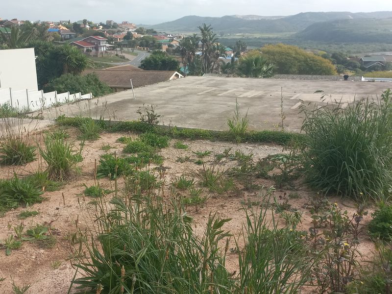 Vacant residential land featuring a concrete slab foundation, retaining walls, and surrounding views of the neighborhood and landscape.