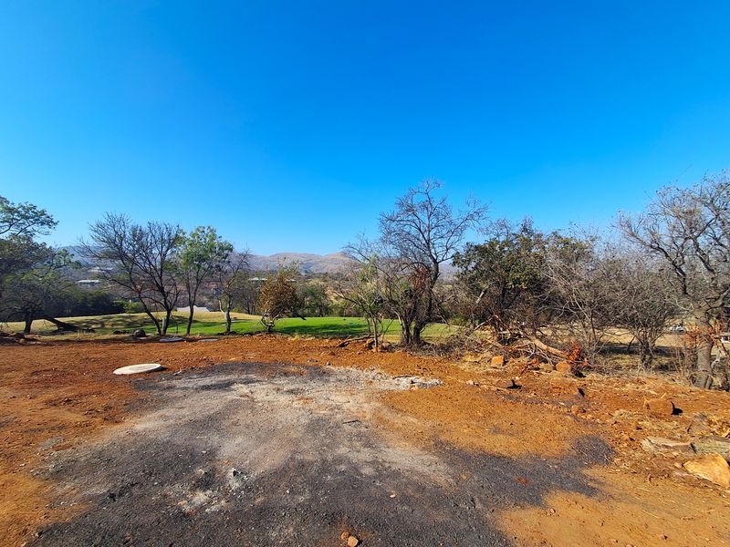 A view of the vacant residential land featuring natural landscape, mature trees, and distant mountain vistas.