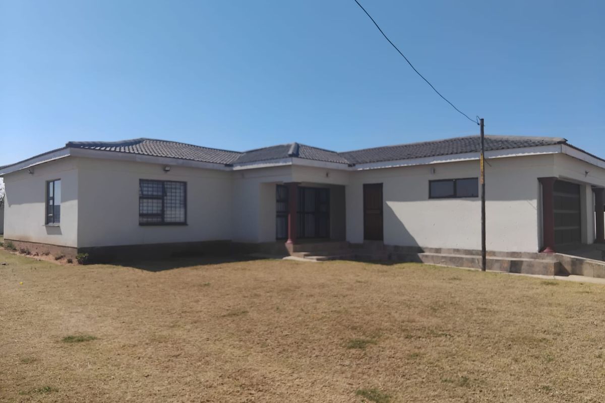 A single-story residential house featuring a tiled roof, security bars on windows, and an attached garage, set on a spacious plot.