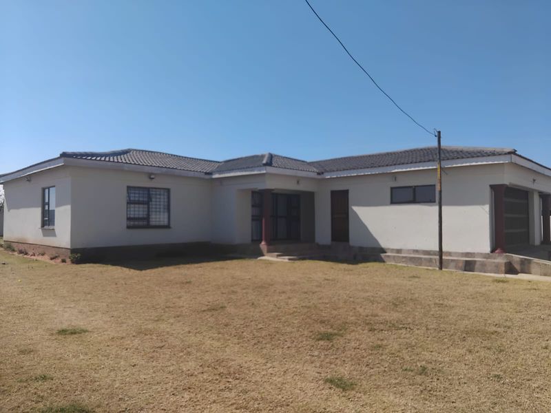 A single-story residential house featuring a tiled roof, security bars on windows, and an attached garage, set on a spacious plot.