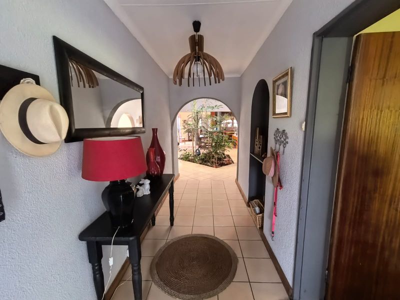 A welcoming entrance hallway featuring tiled flooring, an arched transition to the living area, and a built-in wall niche.