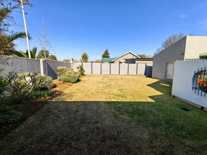 A well-maintained private rear garden featuring a level lawn, perimeter walling, and secure fencing, providing a clean and functional outdoor space.