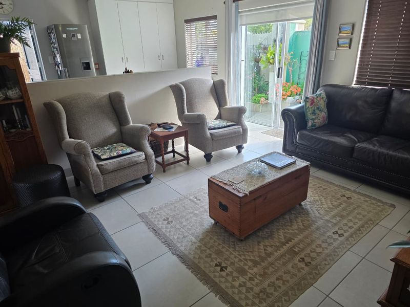 A comfortable living room featuring tiled flooring, built-in cabinetry, and a sliding glass door providing access to the outdoor area.