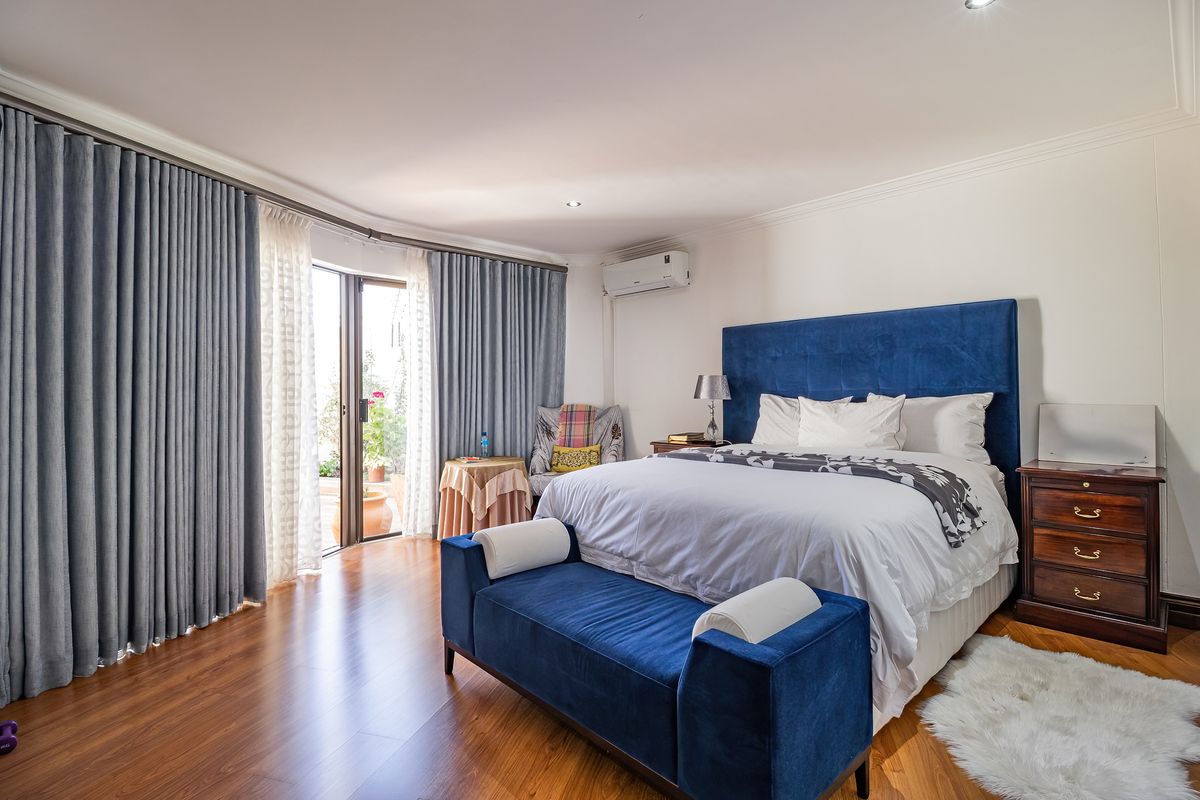 Spacious bedroom featuring laminate flooring, air conditioning, and a sliding glass door providing access to an outdoor area.