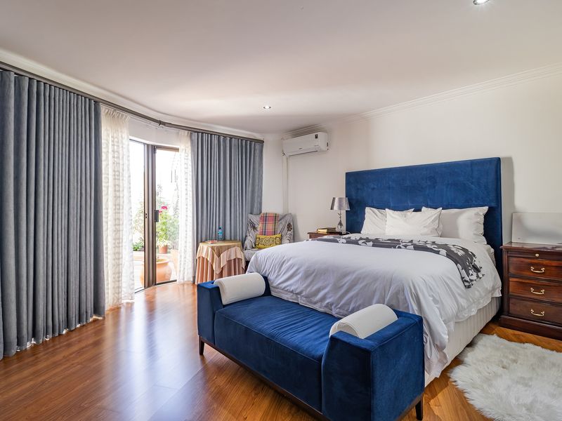 Spacious bedroom featuring laminate flooring, air conditioning, and a sliding glass door providing access to an outdoor area.
