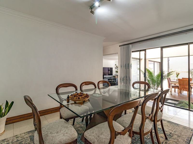 Bright dining room featuring tiled flooring and large sliding glass doors that provide seamless access to the outdoor patio area.