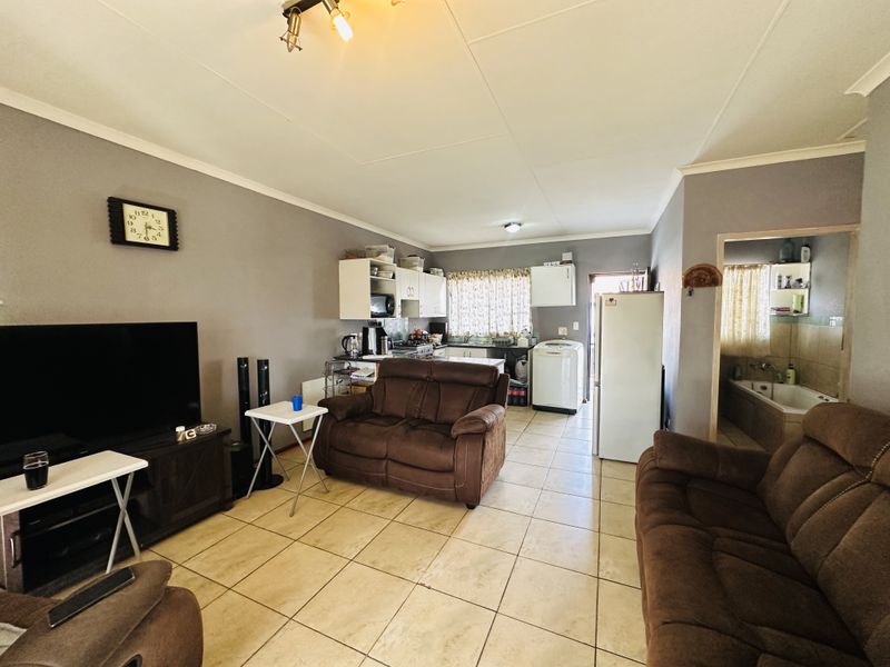 Open-plan living area featuring tiled flooring and a functional kitchen space, providing a versatile layout for daily living and dining.