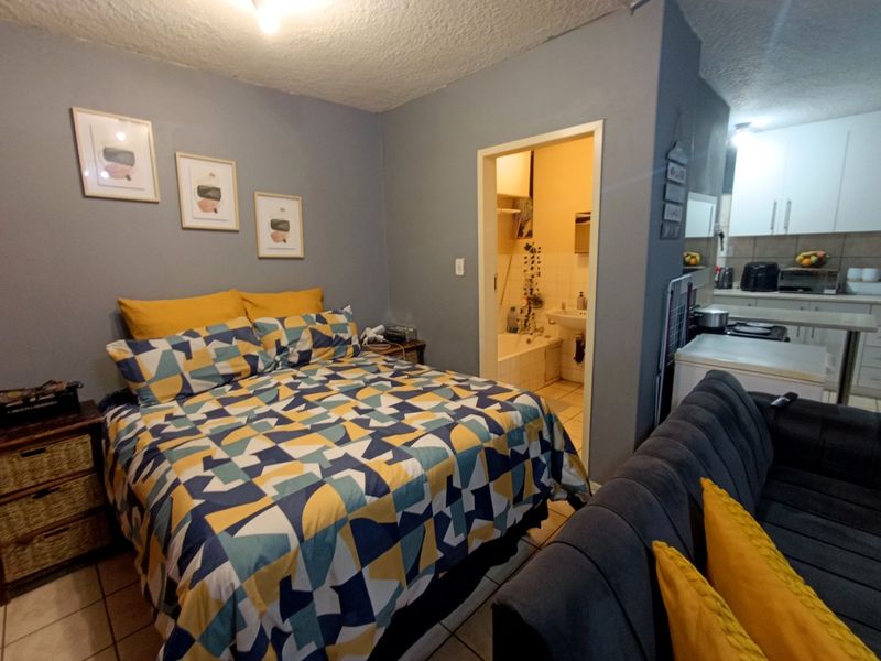 Open-plan studio apartment featuring a combined bedroom and living area with an adjacent kitchen and a compact bathroom.