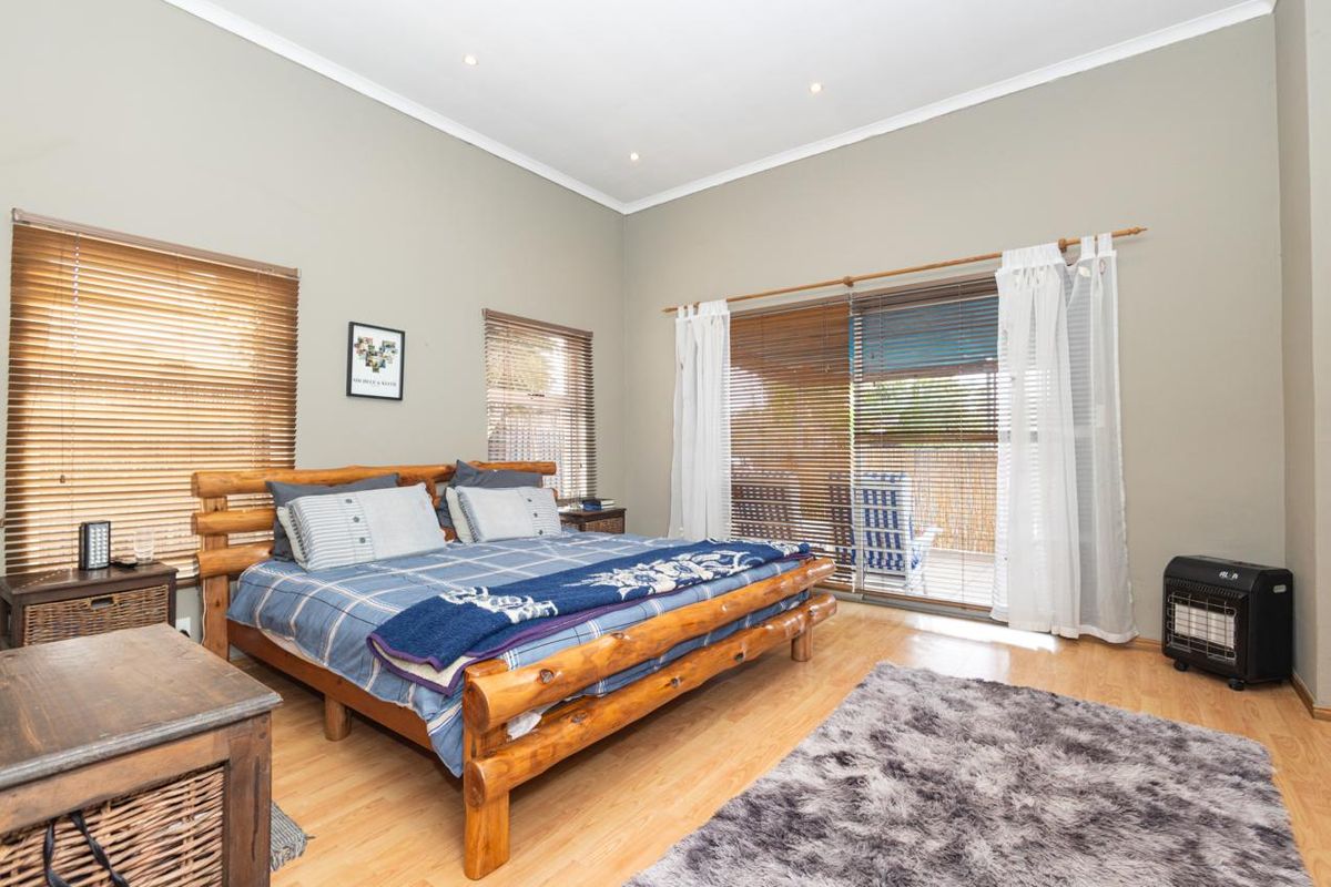 Spacious bedroom featuring laminate flooring, recessed lighting, and sliding glass doors providing direct access to an outdoor patio area.