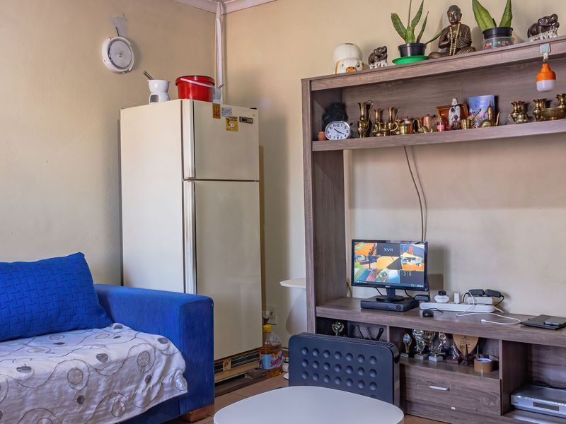 A living area featuring neutral wall finishes and a functional layout, suitable for modernization and updated interior design.
