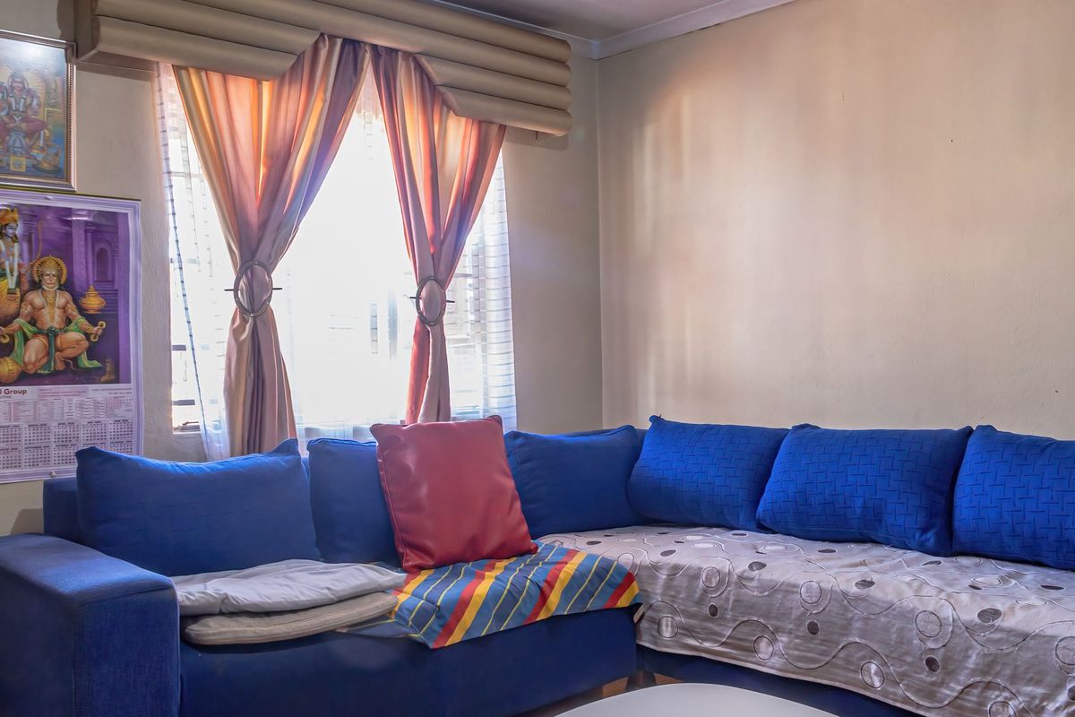 A living room area featuring a window with installed curtain rods and neutral wall finishes.