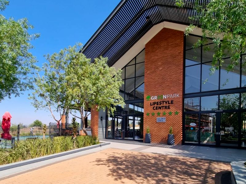 Modern lifestyle centre building featuring a striking brick facade, expansive glass windows, and a well-maintained paved entrance area.