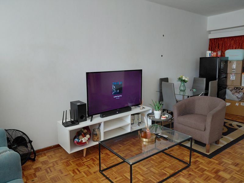 Open plan living and dining area featuring traditional parquet flooring and neutral wall finishes.