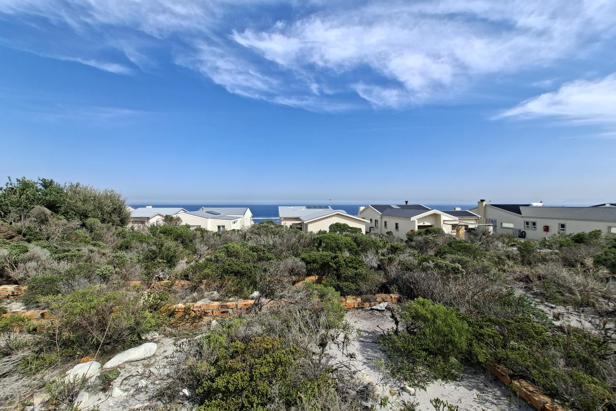 A scenic view of the coastal landscape and surrounding residential properties from the vacant land plot.