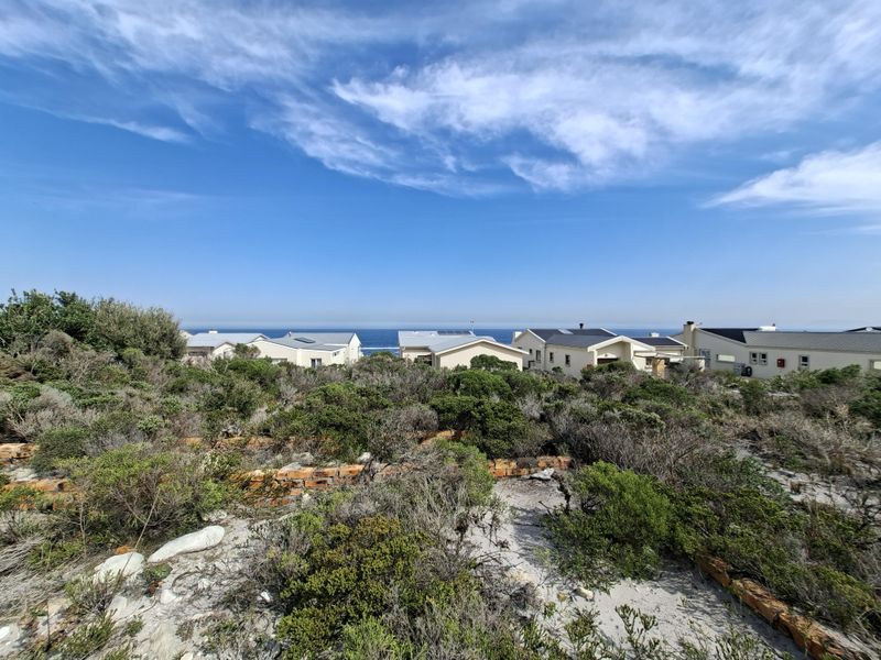 A scenic view of the coastal landscape and surrounding residential properties from the vacant land plot.