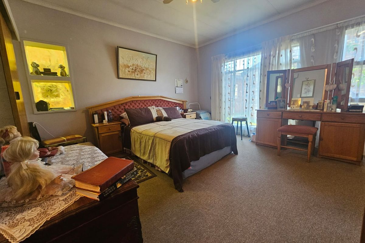 Spacious bedroom featuring carpeted flooring, a ceiling fan, and a built-in recessed wall niche for display.