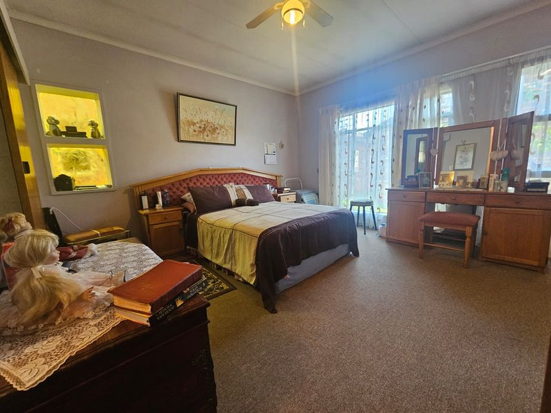 Spacious bedroom featuring carpeted flooring, a ceiling fan, and a built-in recessed wall niche for display.